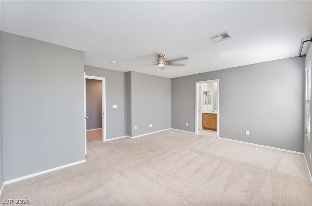 2825 Woodland Park Avenue, North Las Vegas, NV 89086 Soft carpeting pairs with neutral walls in this comfortable bedroom featuring an attached bath.