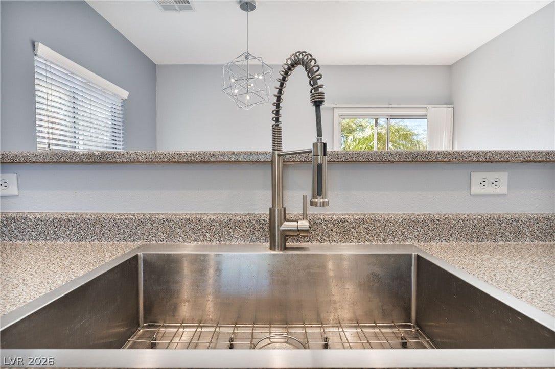2825 Woodland Park Avenue, North Las Vegas, NV 89086 An undermount stainless steel sink pairs with stone counters in this functional workspace.