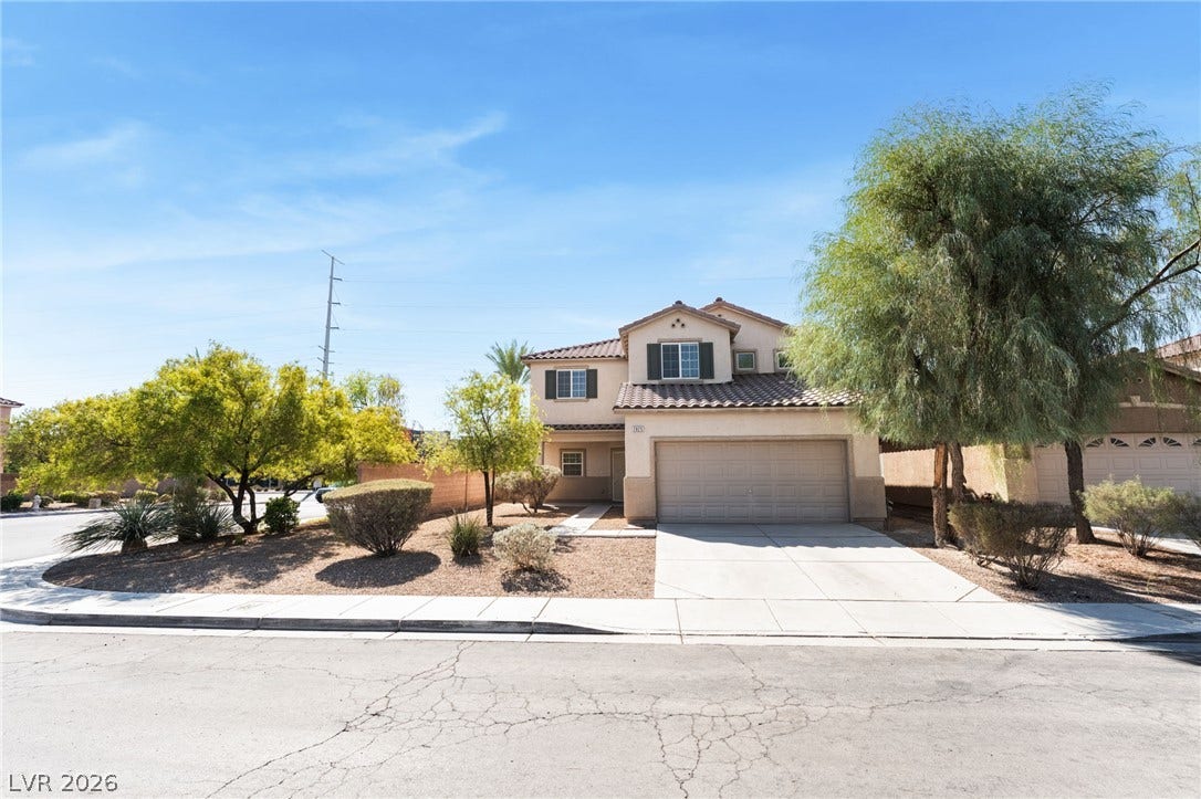 2825 Woodland Park Avenue, North Las Vegas, NV 89086 A classic stucco exterior with shuttered windows sits nestled on a landscaped corner lot.