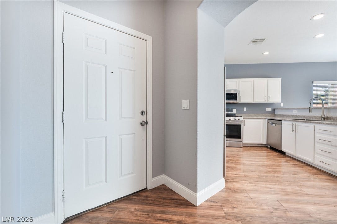 2825 Woodland Park Avenue, North Las Vegas, NV 89086 Warm wood flooring guides the way from the front entryway into an open-concept kitchen.