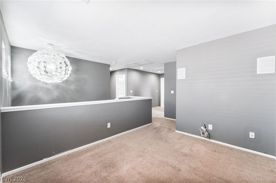 2825 Woodland Park Avenue, North Las Vegas, NV 89086 An open upper-level loft area features neutral carpeting and a statement light fixture.