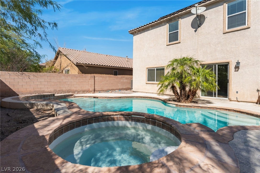 2825 Woodland Park Avenue, North Las Vegas, NV 89086 An inviting backyard oasis features a custom in-ground pool paired with an integrated circular spa.