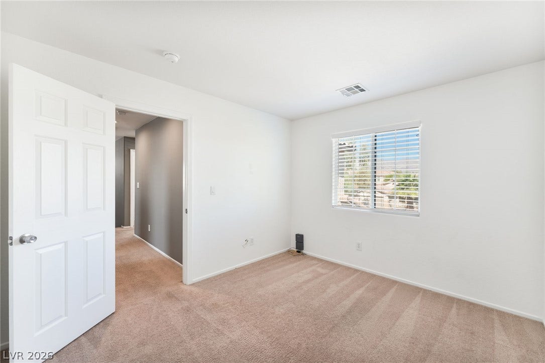 2825 Woodland Park Avenue, North Las Vegas, NV 89086 Soft carpeting pairs with a multi-pane window to create a comfortable, sunlit bedroom design.