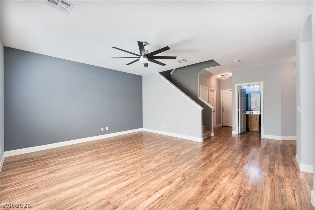 2825 Woodland Park Avenue, North Las Vegas, NV 89086 Warm wood flooring and an open layout define this versatile living space next to the staircase.
