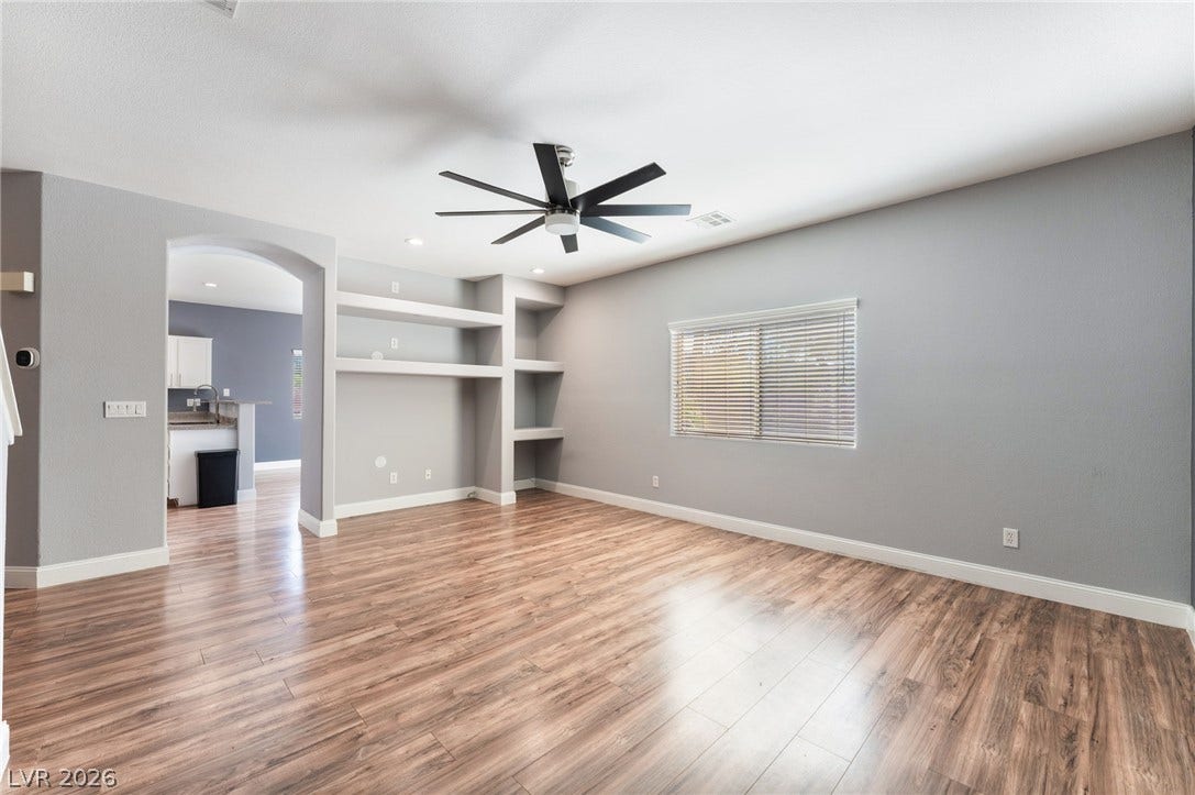 2825 Woodland Park Avenue, North Las Vegas, NV 89086 Rich wood-look flooring and built-in shelving anchor this versatile living space.