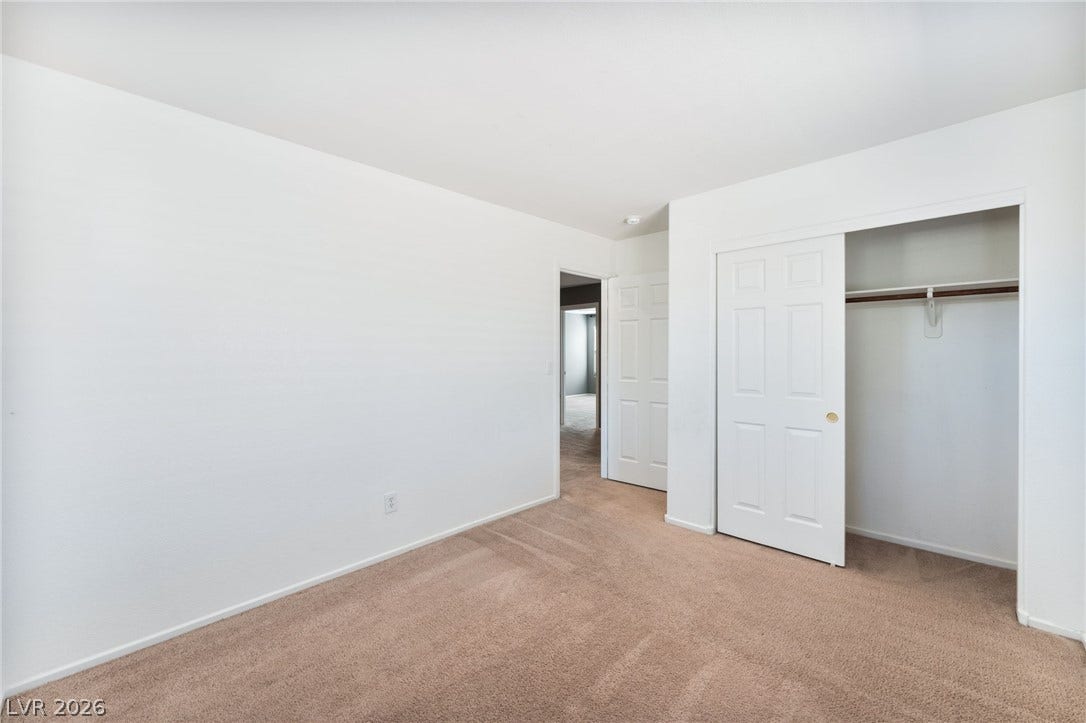 2825 Woodland Park Avenue, North Las Vegas, NV 89086 Plush carpeting anchors this clean bedroom featuring a convenient sliding door closet setup.