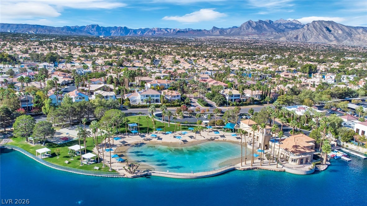 Majestic mountain ridges frame a pristine community lakefront with resort-style sandy shores.