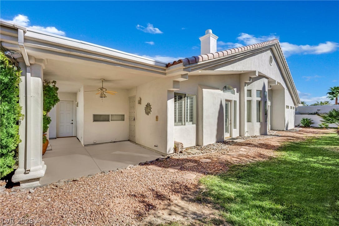 An inviting covered patio area transitions smoothly to the grassy side yard.