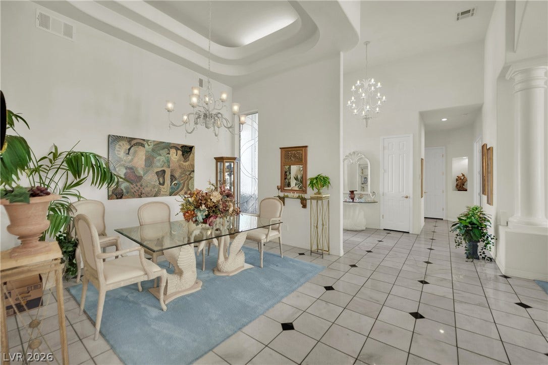 Soaring tray ceilings and elegant tile floors define this light-filled dining space.