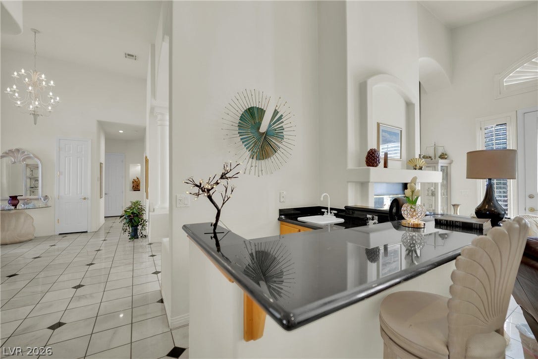 Polished stone floors and soaring ceilings create an elegant transition between living areas.
