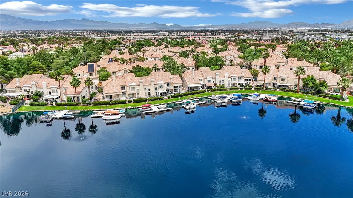 Boats line the private docks of this waterfront community framed by distant mountain peaks.