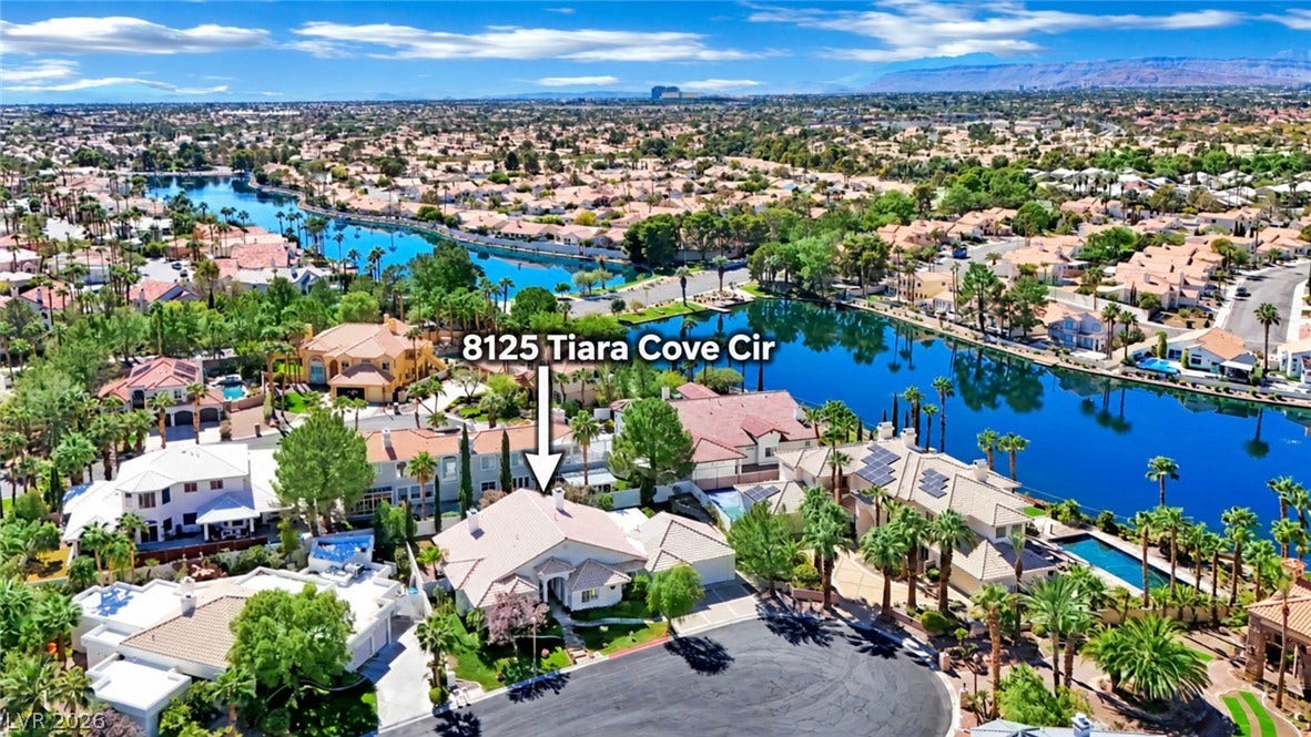 An aerial perspective showcases a tile-roofed residence nestled along a scenic, curving waterway.