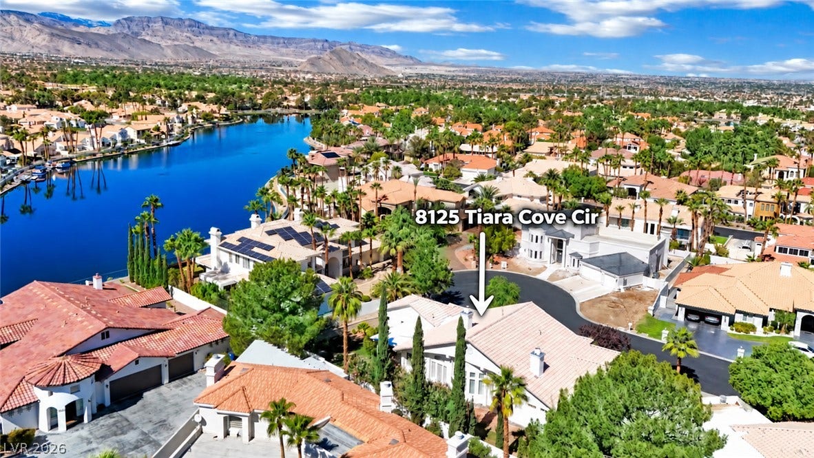 An aerial perspective showcases a peaceful lakeside setting framed by mountains in the distance.