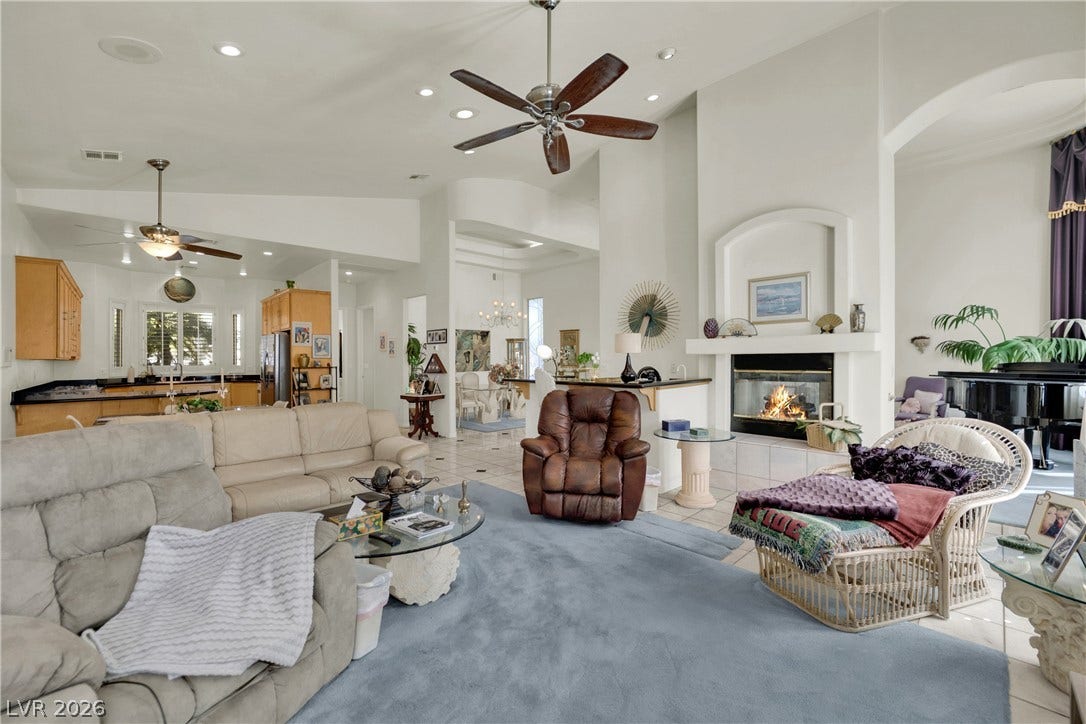 High ceilings, tiled flooring, and a cozy fireplace define this open living space.