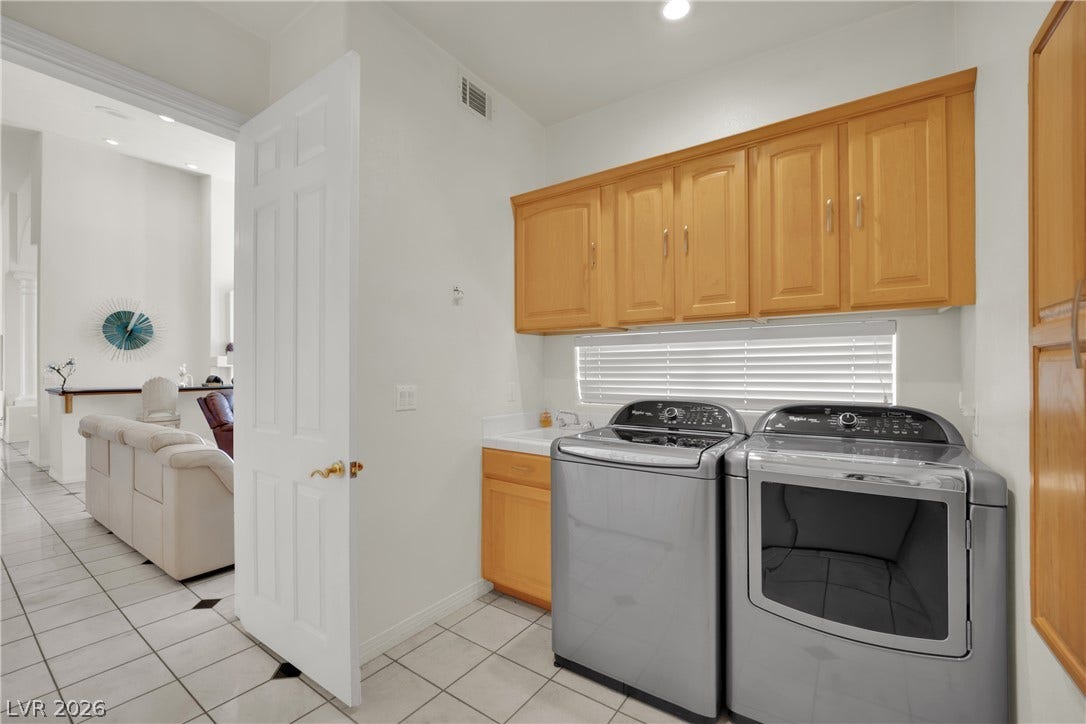 Ample built-in cabinetry provides extensive storage in this practical laundry room.