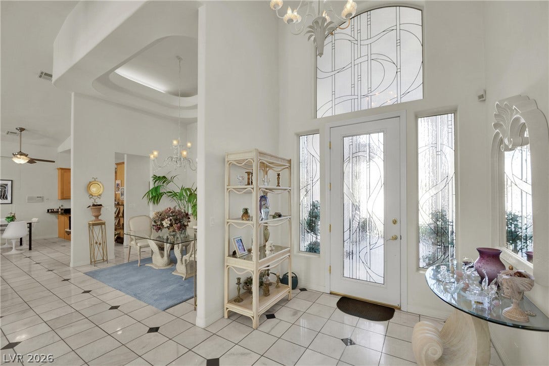 Double-height ceilings and custom art glass windows create a grand, airy entrance foyer.