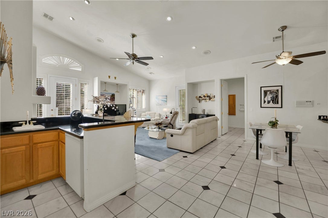 A spacious kitchen area opens seamlessly to a bright living space with tiled flooring throughout.