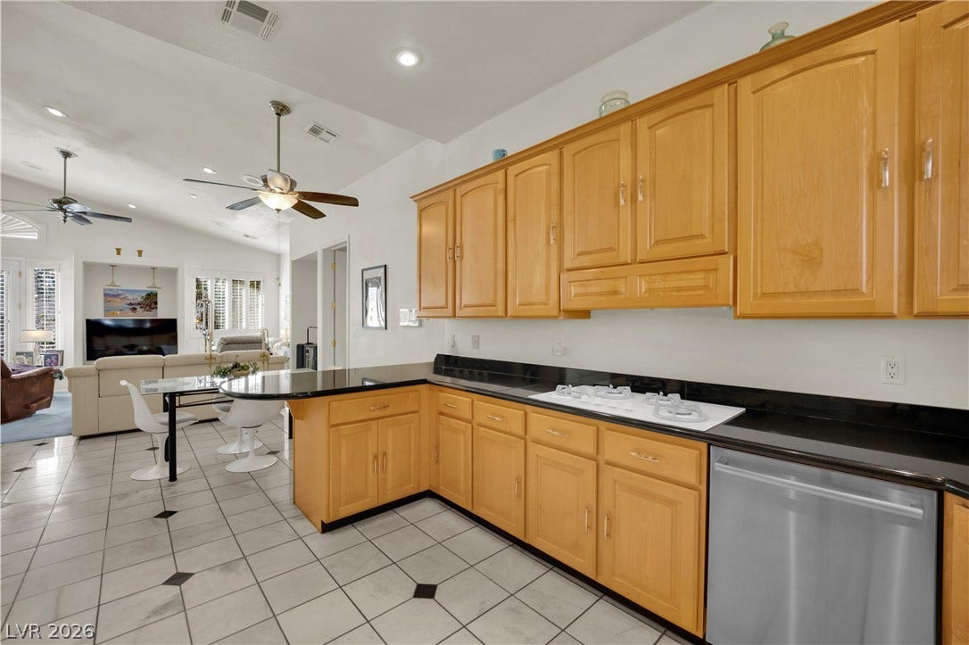 Gleaming tile floors and natural wood cabinetry anchor this spacious culinary workspace.