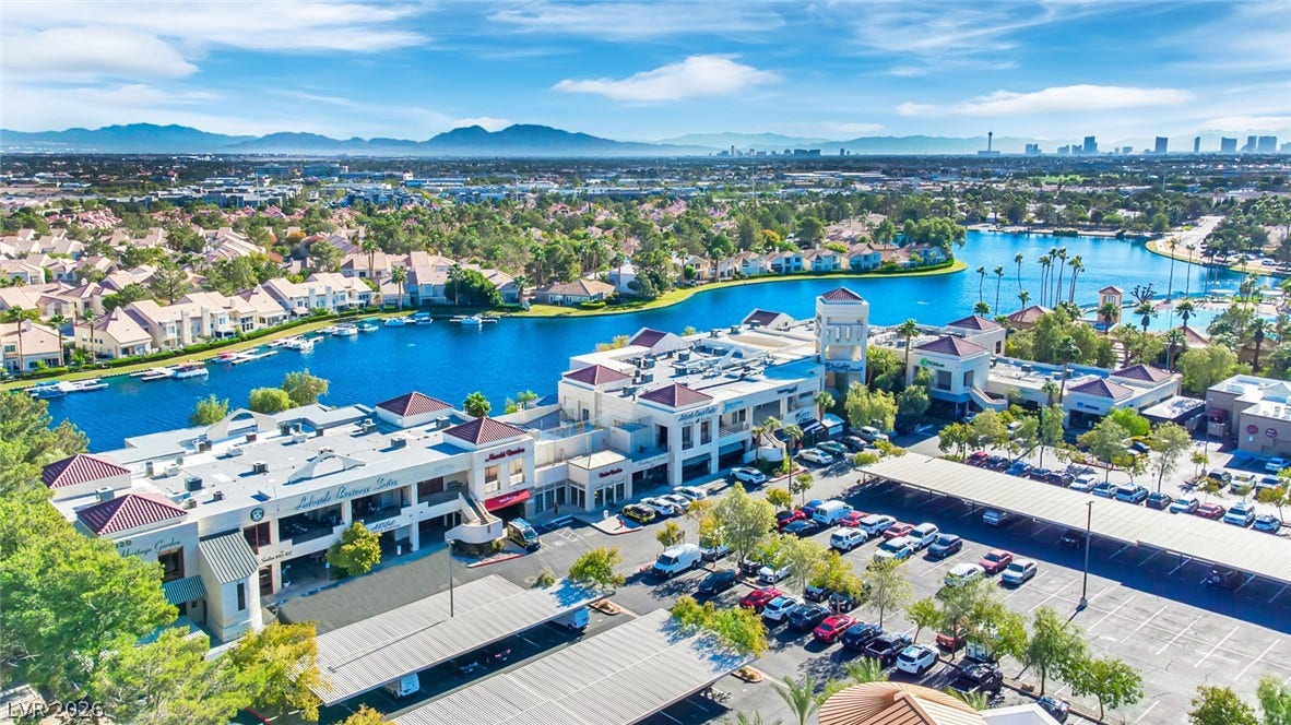 An aerial perspective showcases a vibrant lakeside community framed by distant mountain peaks.