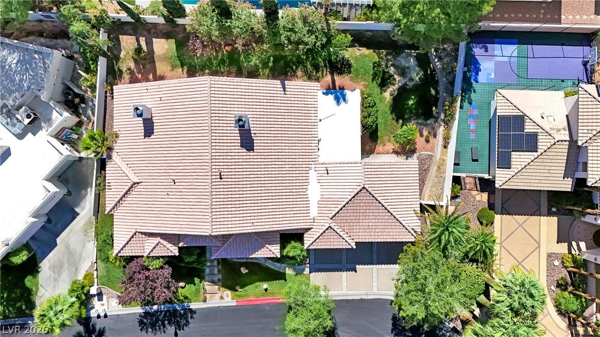 An aerial perspective reveals a tile roof and manicured green spaces surrounding the residence.
