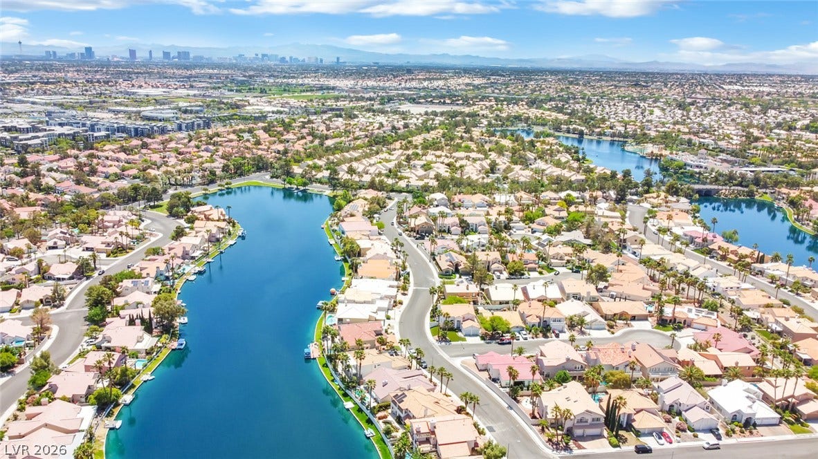 A quiet lake highlights this peaceful neighborhood under blue skies.