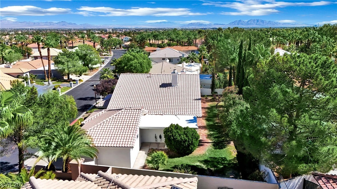 Lush mature trees surround this classic tile roof home showcasing panoramic mountain views.