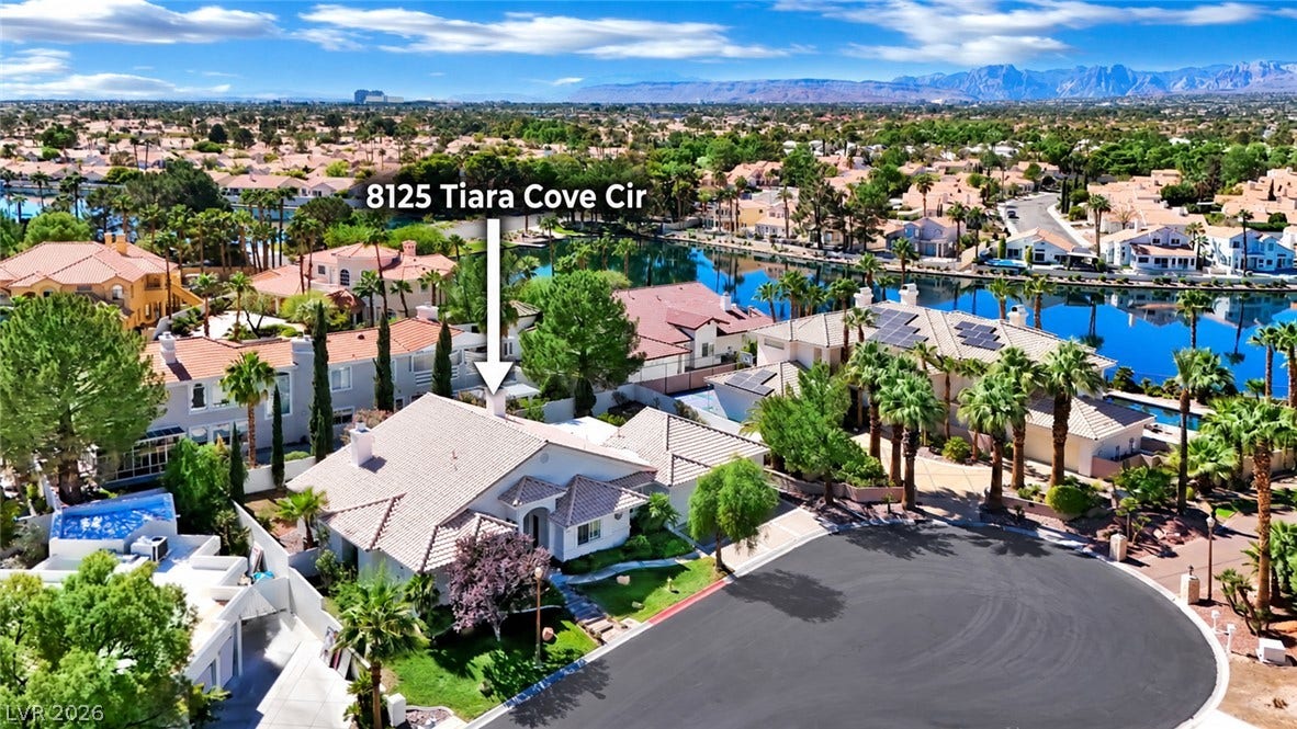 An aerial perspective showcases a tile-roofed home nestled along a quiet, tree-lined cul-de-sac.