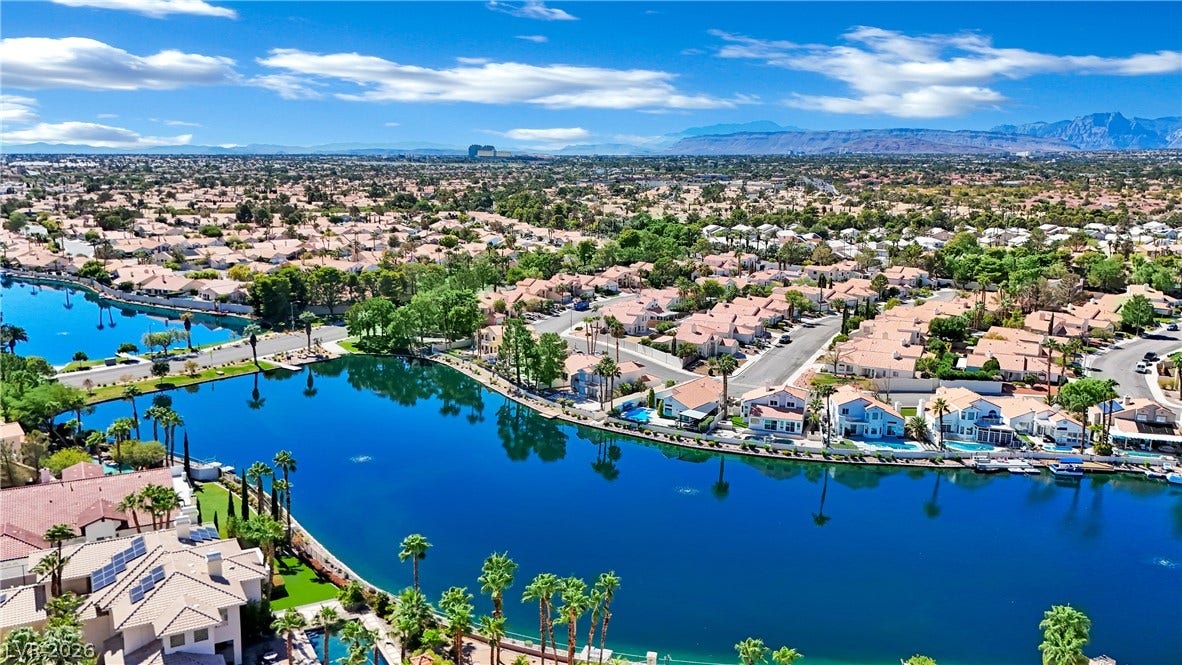 A quiet lake highlights this neighborhood surrounded by mountains in the distance.