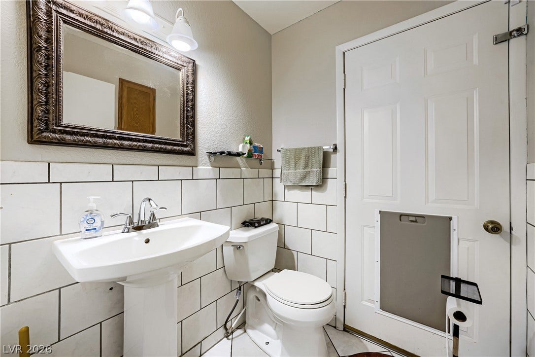 3536 Golden Pedal Street, Las Vegas, NV 89129 Crisp subway tile walls and a classic pedestal sink define this functional bathroom space.