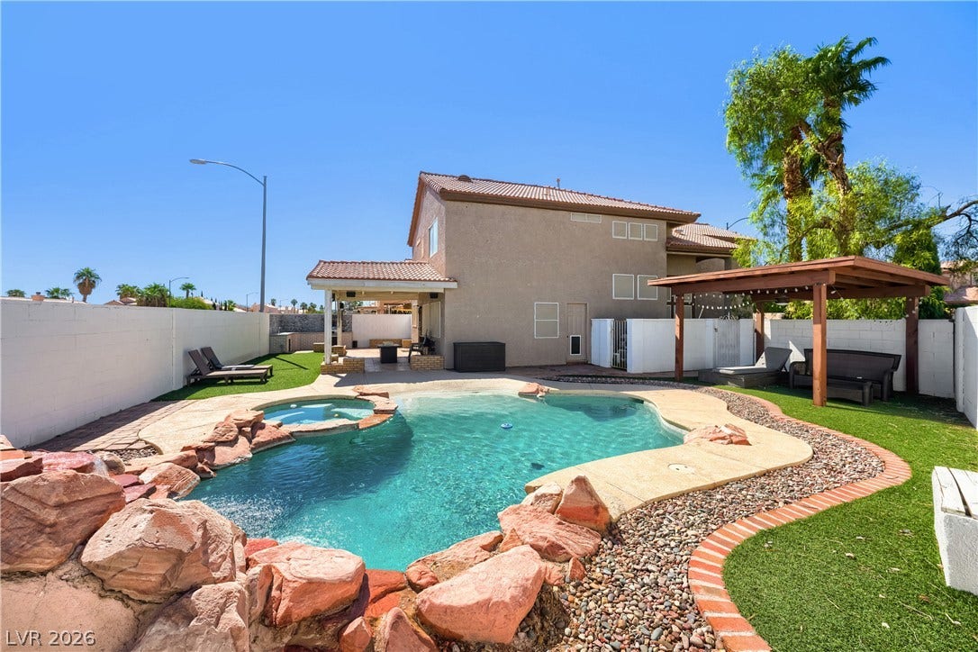 3536 Golden Pedal Street, Las Vegas, NV 89129 A sparkling freeform pool with integrated rock features anchors this spacious private backyard retreat.