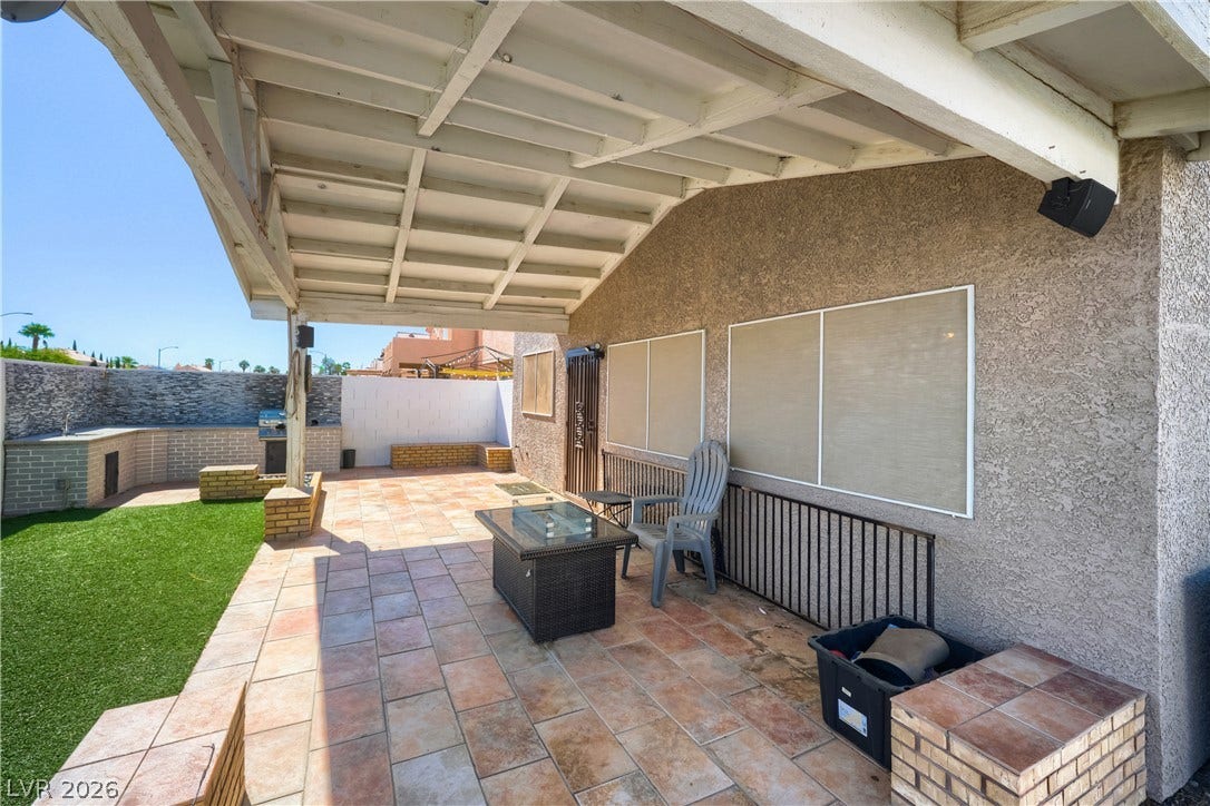 3536 Golden Pedal Street, Las Vegas, NV 89129 A spacious covered patio features durable tile flooring alongside stucco and brick exterior accents.