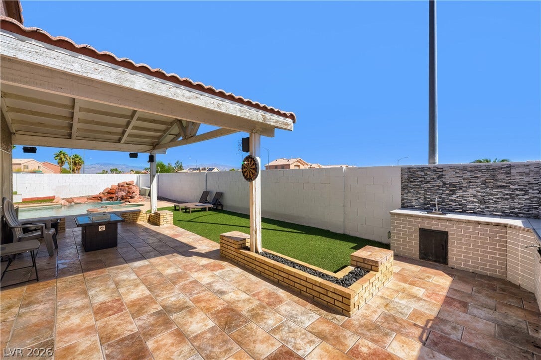 3536 Golden Pedal Street, Las Vegas, NV 89129 Tiled patio spaces flow seamlessly toward a private pool under clear blue skies.