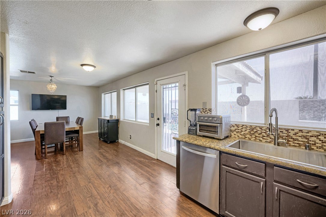 3536 Golden Pedal Street, Las Vegas, NV 89129 Rich wood-look flooring connects the preparation area to a bright dining space.