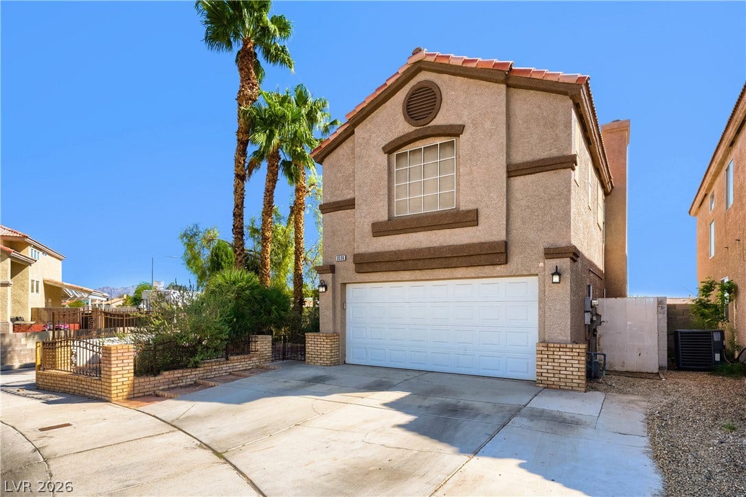 3536 Golden Pedal Street, Las Vegas, NV 89129 A wide concrete driveway leads to the integrated two-car garage of this multi-level home.
