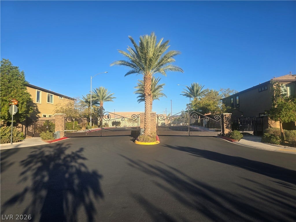 2926 Tremont Avenue, Henderson, NV 89052 Secure gated entryway features ornate iron gates flanked by decorative stone pillars and mature palms.