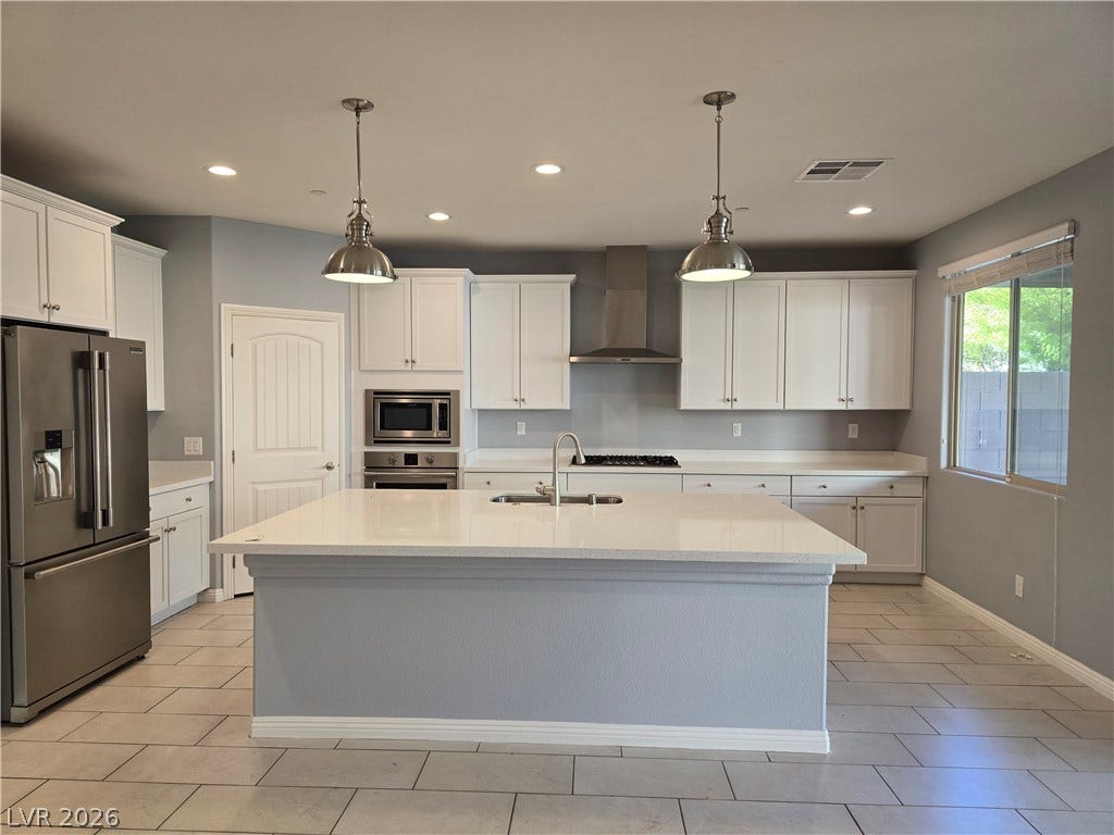 2926 Tremont Avenue, Henderson, NV 89052 An expansive central island anchor this modern kitchen with stone counters and tile flooring.