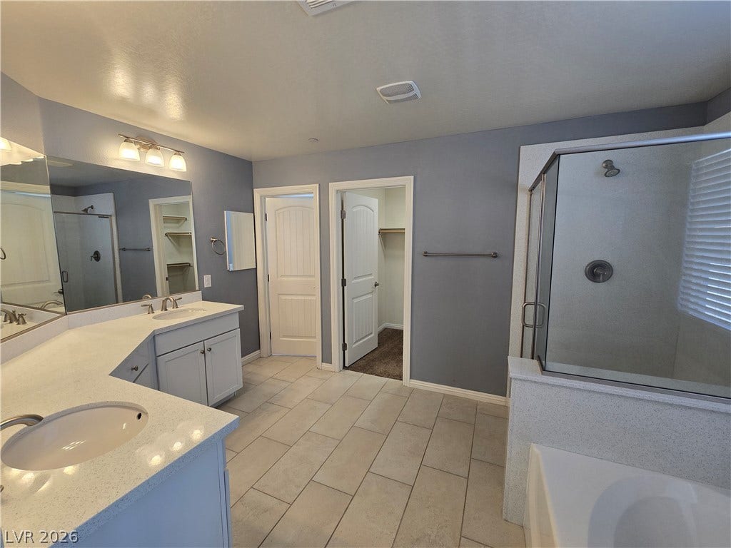 2926 Tremont Avenue, Henderson, NV 89052 Tiled flooring and a separate walk-in shower define this spacious primary bathroom.