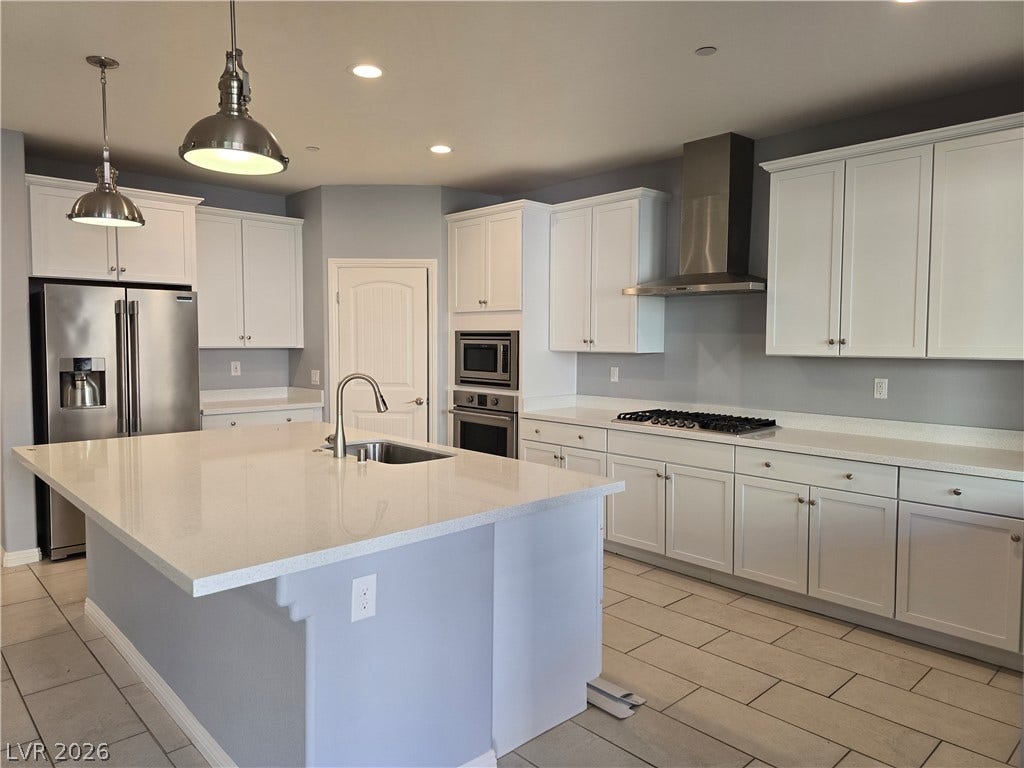 2926 Tremont Avenue, Henderson, NV 89052 Gleaming stone countertops and a spacious central island anchor this modern culinary workspace.