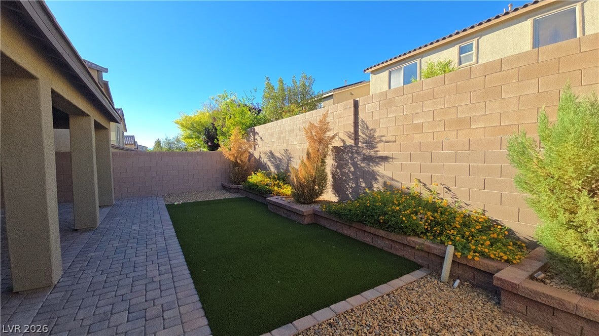 2926 Tremont Avenue, Henderson, NV 89052 High block walls frame a private yard featuring low-maintenance pavers and raised planter beds.