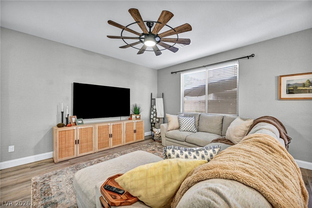 Smooth wood floors and tall ceilings anchor this inviting main living area.