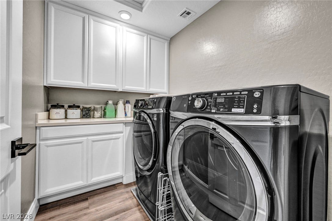 Abundant built-in cabinetry provides efficient storage alongside rich wood-look flooring.