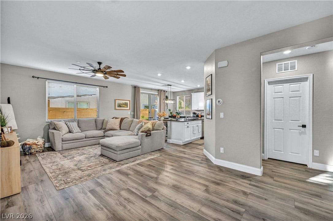 Warm wood-look flooring anchors this inviting open-concept layout connecting the living area and kitchen.