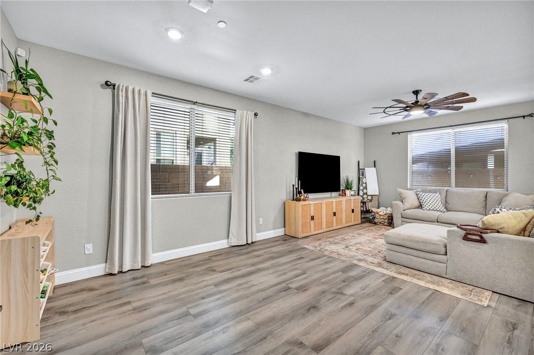 Generous windows fill this modern living space with natural light highlighting the rich wood flooring.