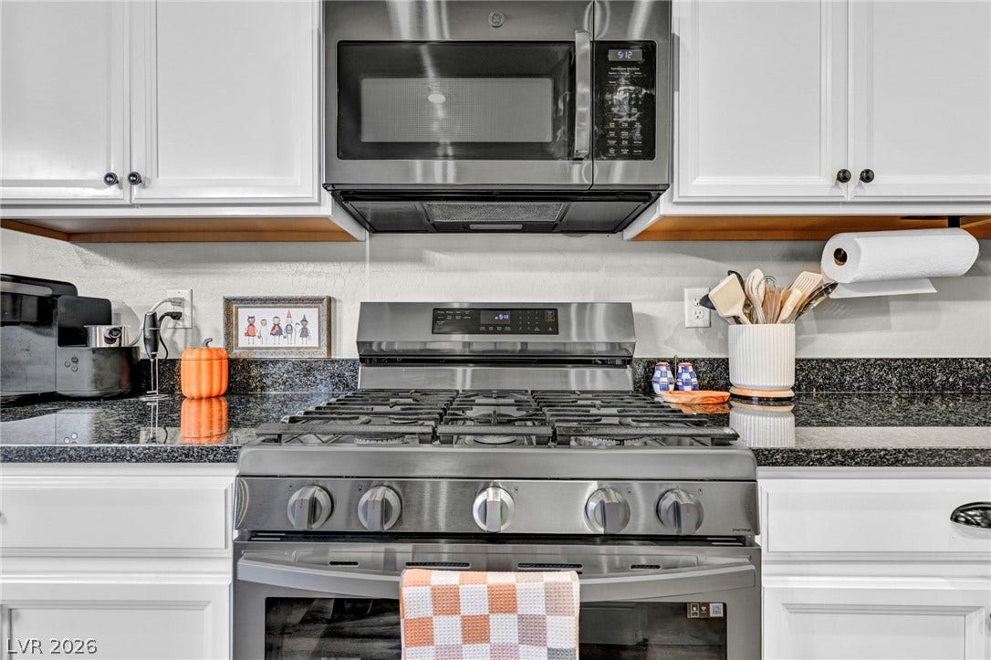 Polished granite countertops complement modern cabinetry and stainless steel appliances.