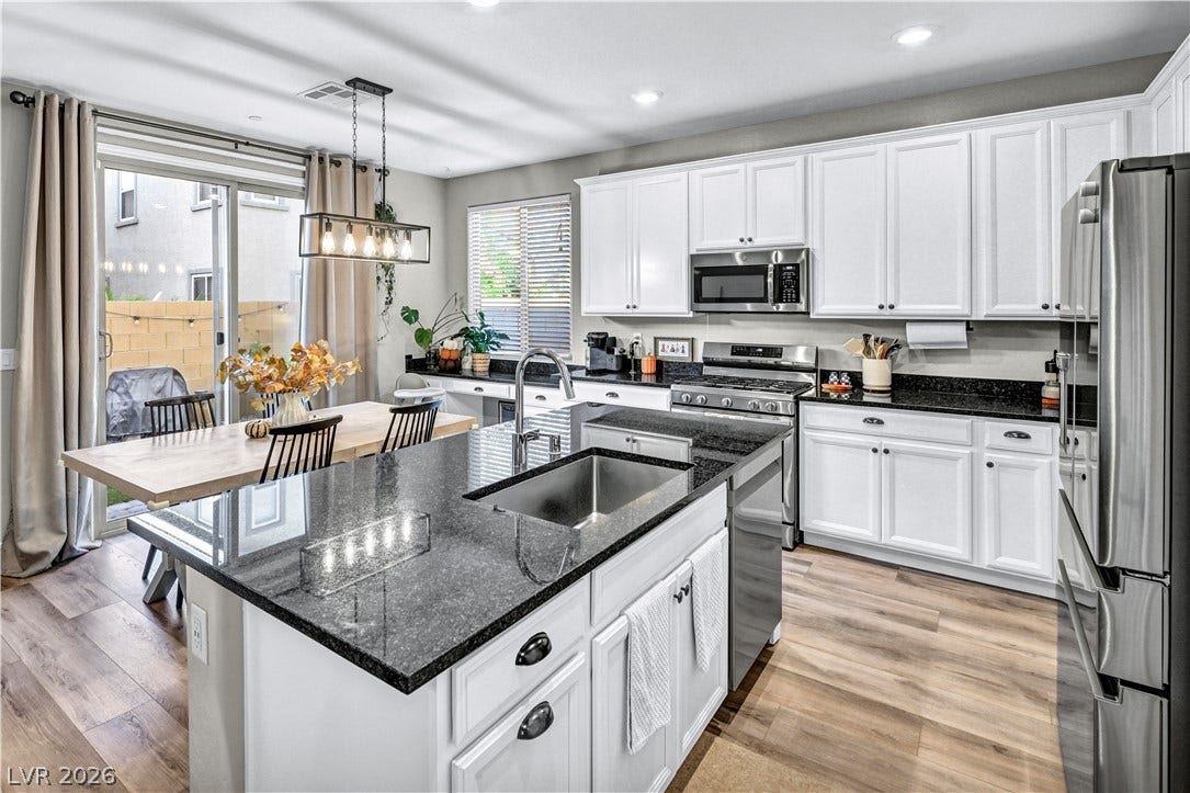 Polished granite countertops and classic white cabinetry define this modern culinary workspace.