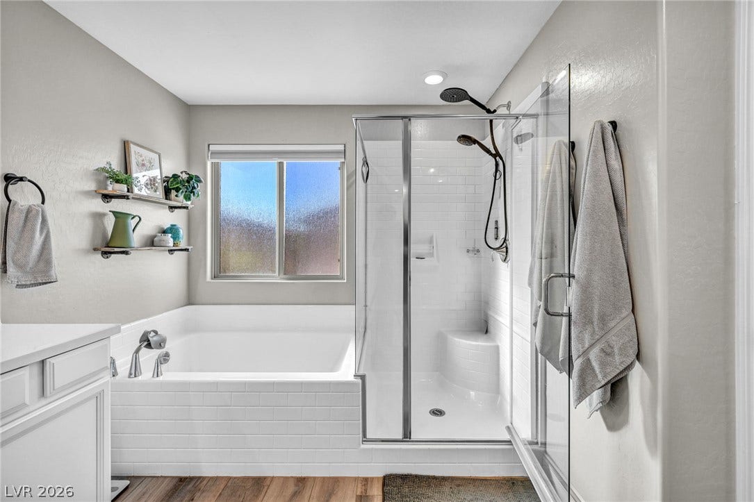 A glass-enclosed shower alongside a deep soaking tub provides a spa-like retreat.