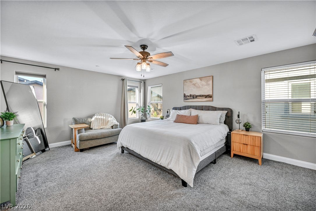 An abundance of natural light fills this spacious bedroom lined with wall-to-wall carpeting.
