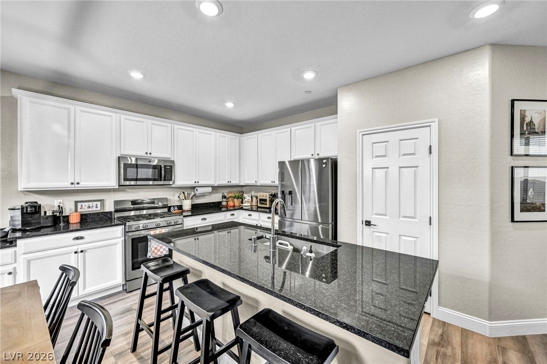 Polished granite countertops and classic cabinetry define this functional kitchen space.