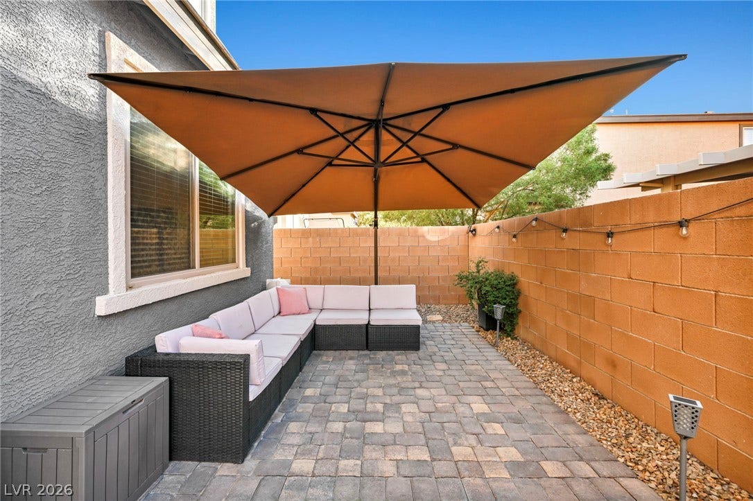 An inviting stone paver patio sits enclosed within privacy block fencing.