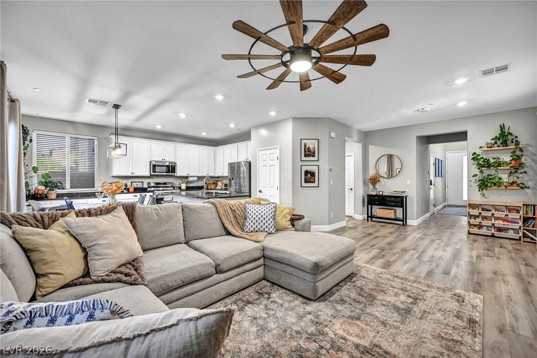 An open floor plan connects the living area to the kitchen over durable wood flooring.